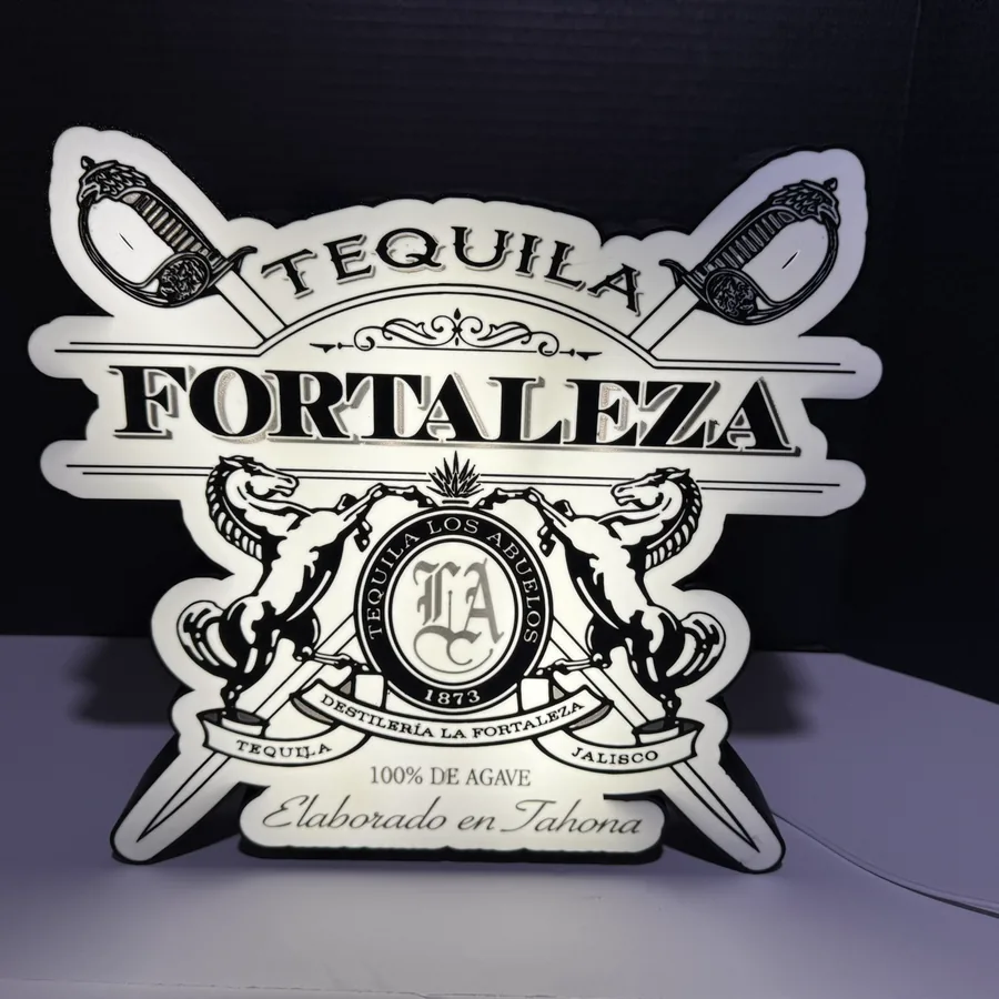 Backlit Tequila Fortaleza light box glowing in a dark room